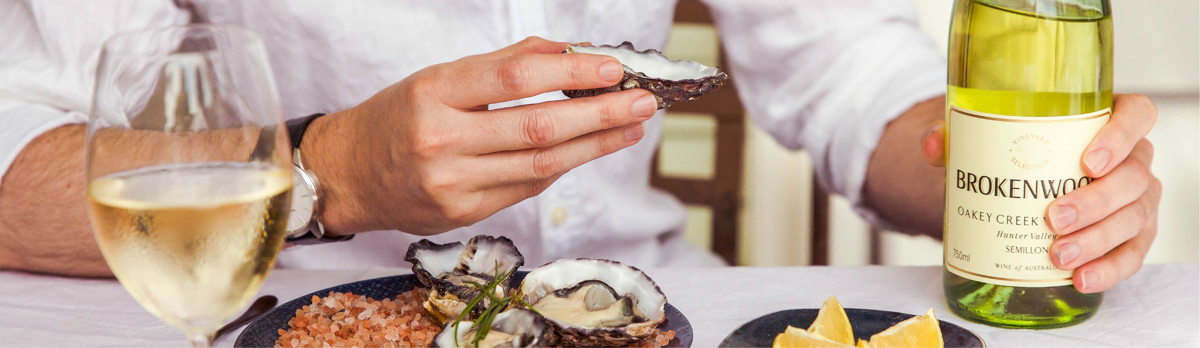 Man having a meal with seafood and white wine from Brokenwood