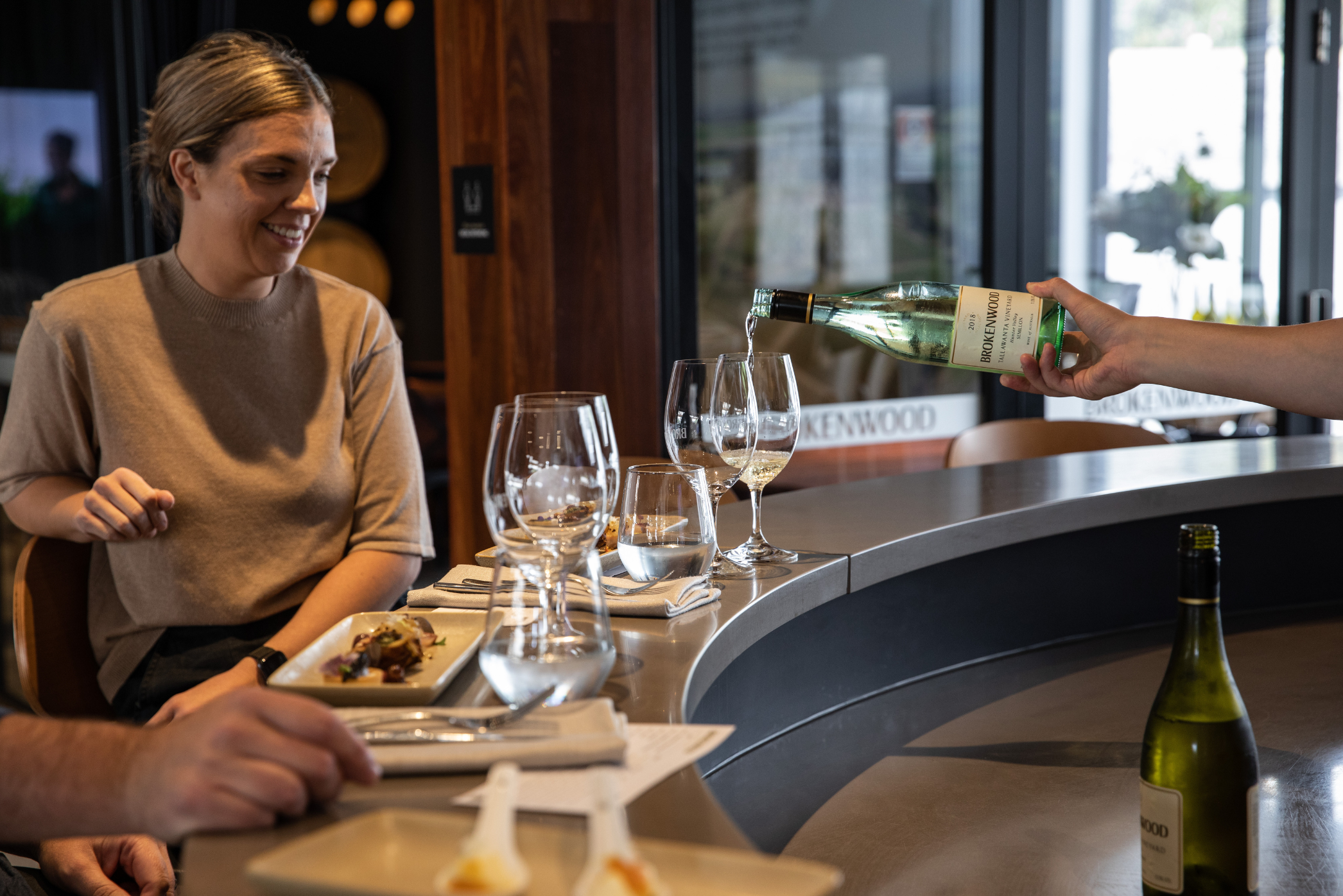 several glasses of wine arranged on a table where a person is having a meal